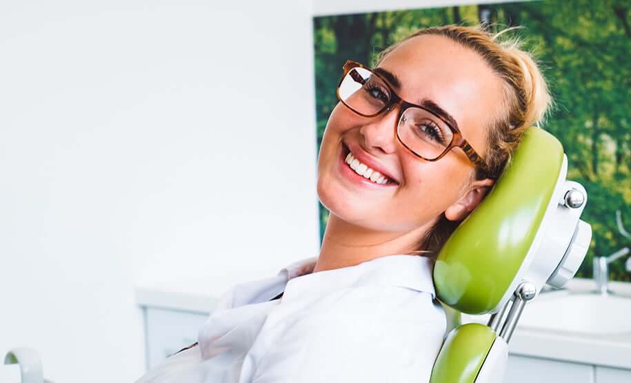 smiling young woman in dental chair